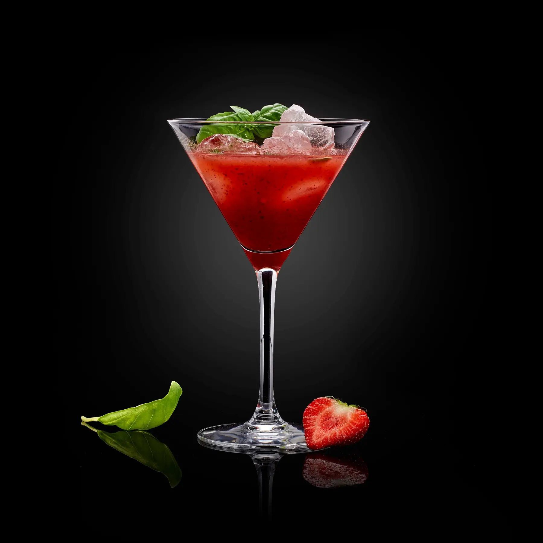 Cocktail rouge à la fraise photographié en studio sur fond noir